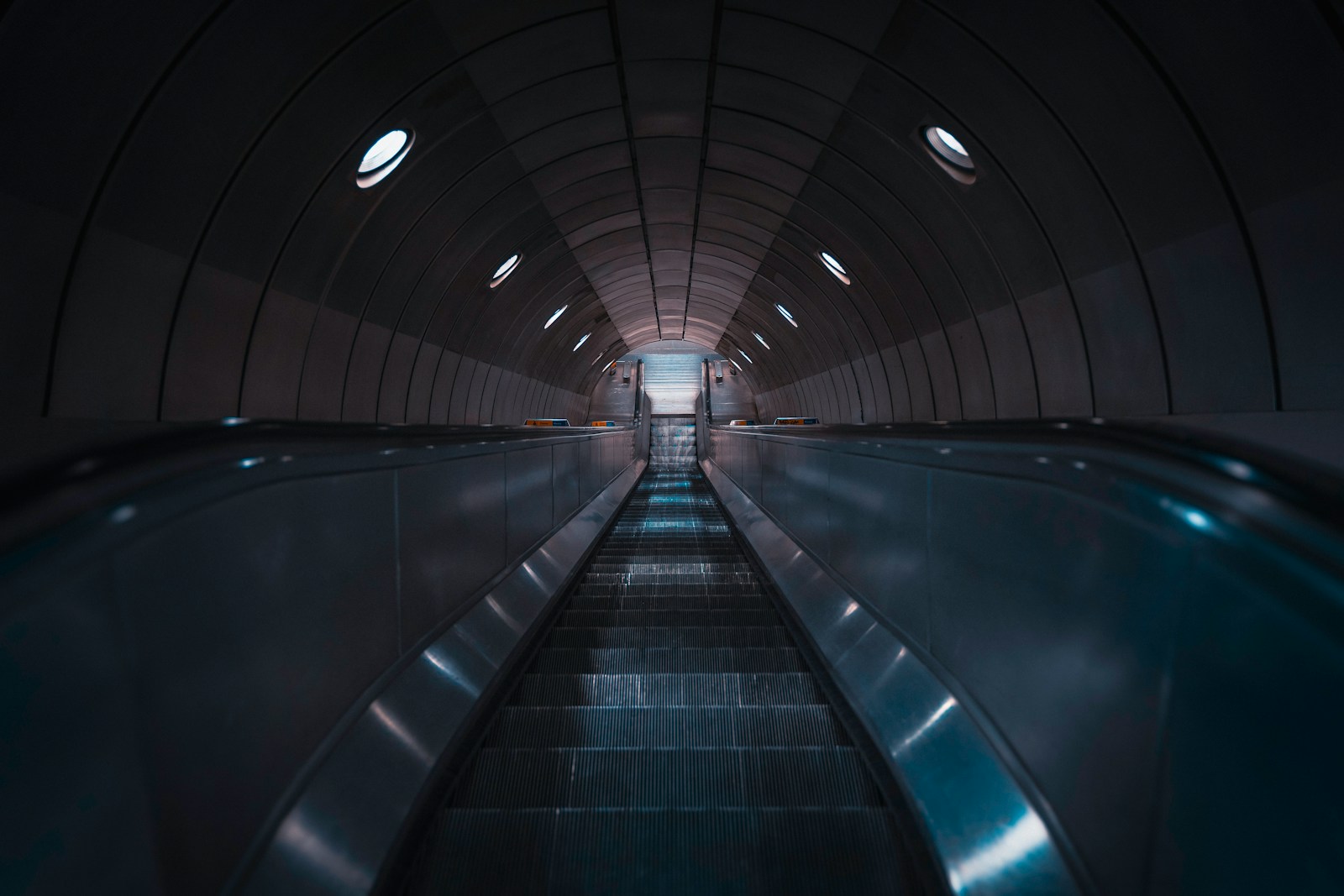 an escalator in a subway station with lights on